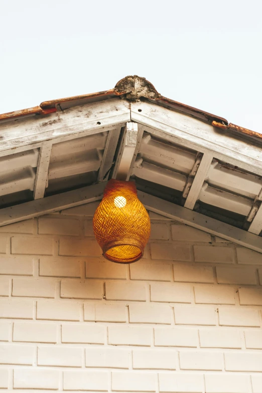 a small light fixture hangs off the side of a brick building