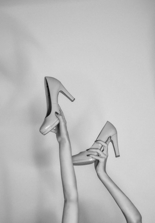 a pencil drawing of a person's legs holding a pair of high heels