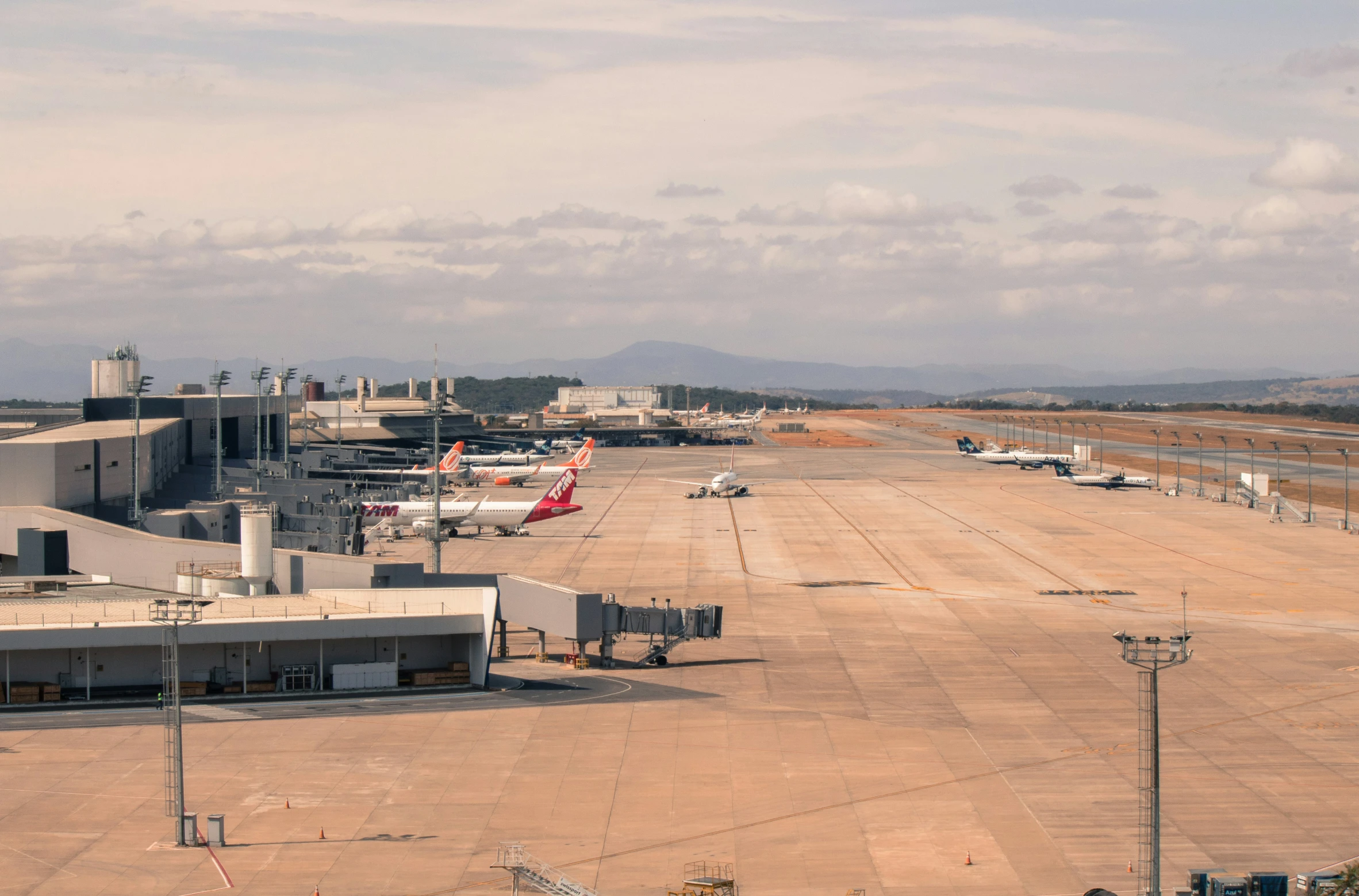 some planes parked in front of large terminal buildings