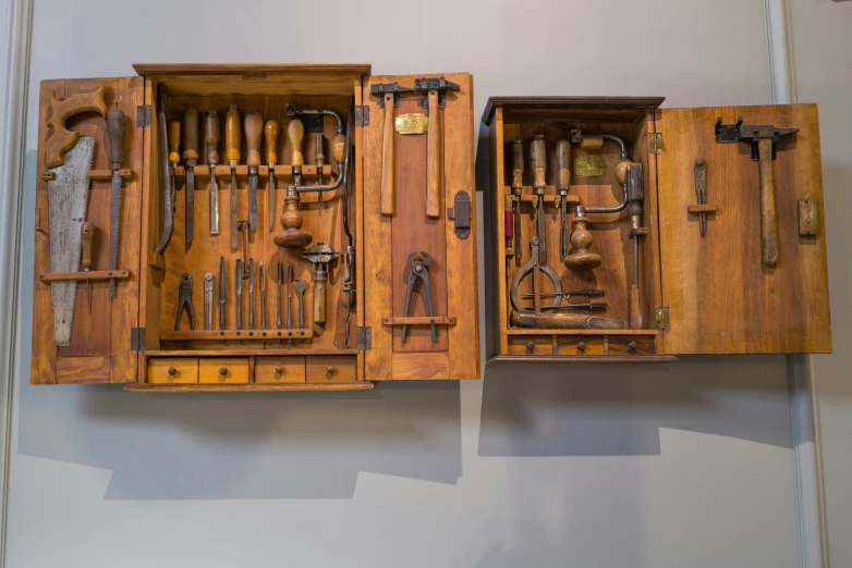 two wooden tool boxes with some tools inside