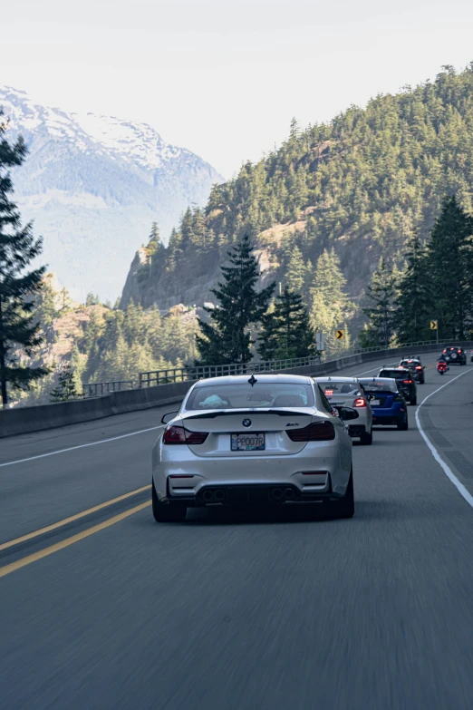 cars are travelling along the highway in front of a mountain range