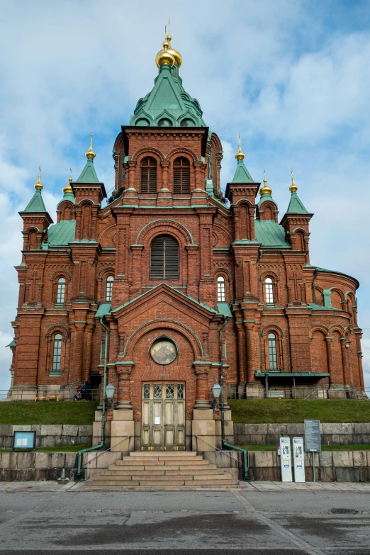 an old brick church with a massive blue steeple and spire