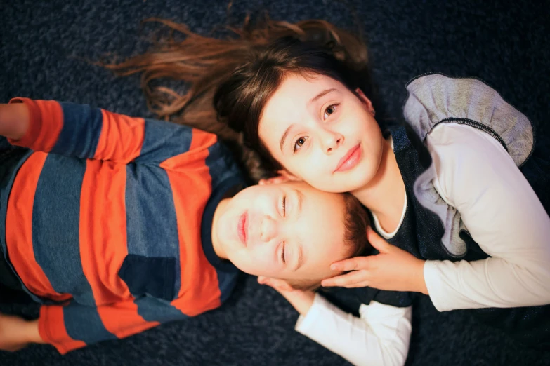 two girls and a boy laying down next to each other