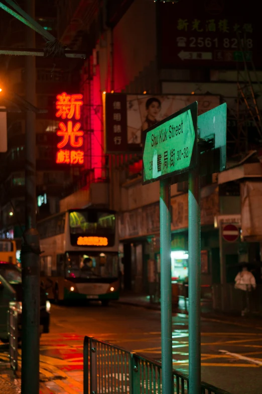 an asian street sign with a bus in the background