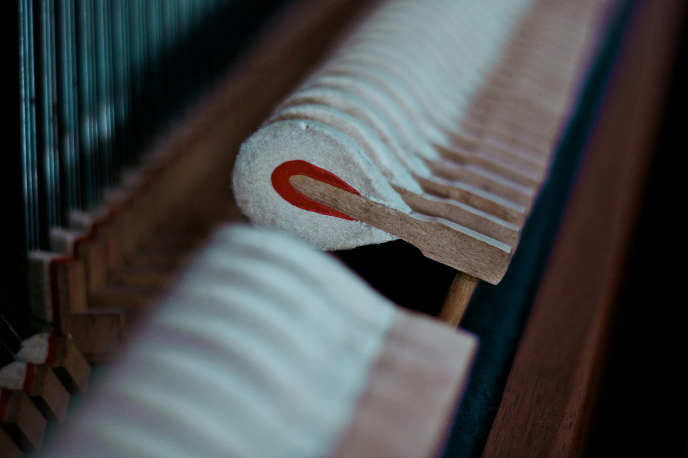 a close up of the end of a wooden bench with red marks