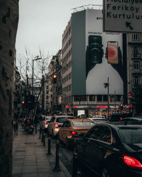 a street with parked cars and people walking along the side