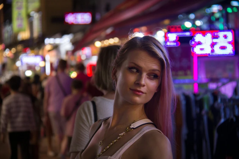 a woman is standing in front of an asian market at night