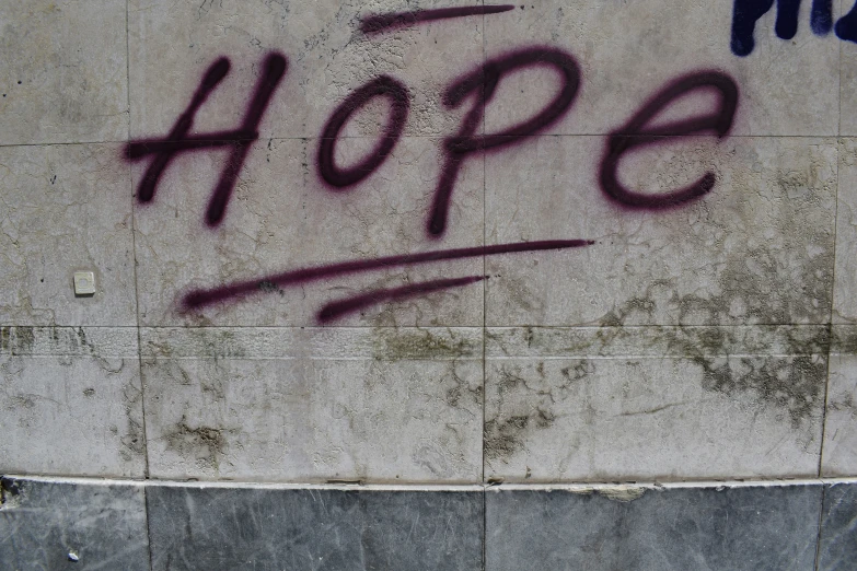 the words hope are spray painted onto the wall