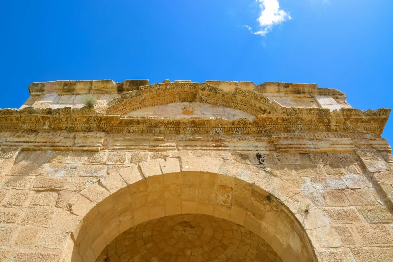 a stone archway and a blue sky and clouds