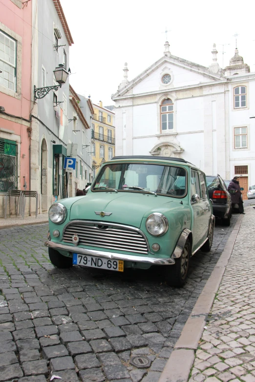 there is a small green car parked on the street