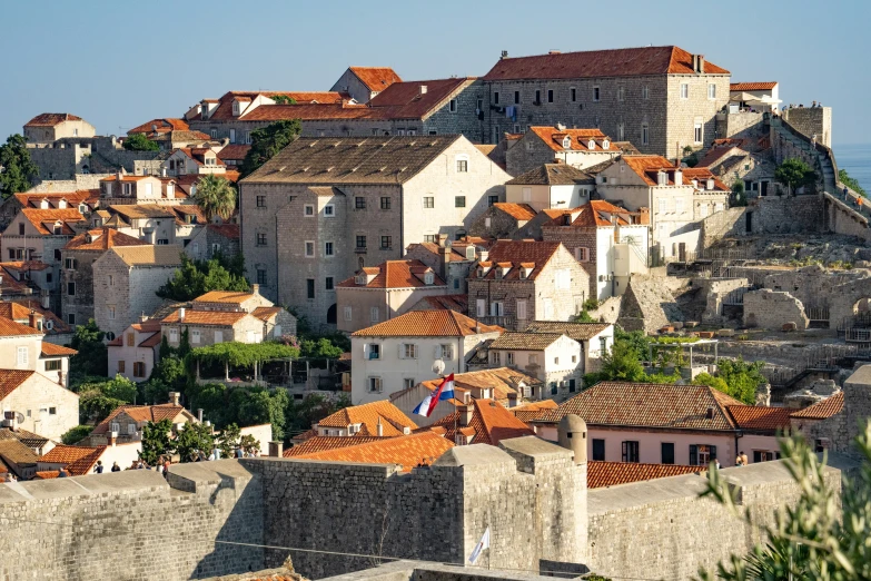 an aerial view of a city with lots of buildings and orange roofs