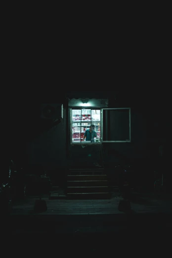 a man walking outside of a window in the dark