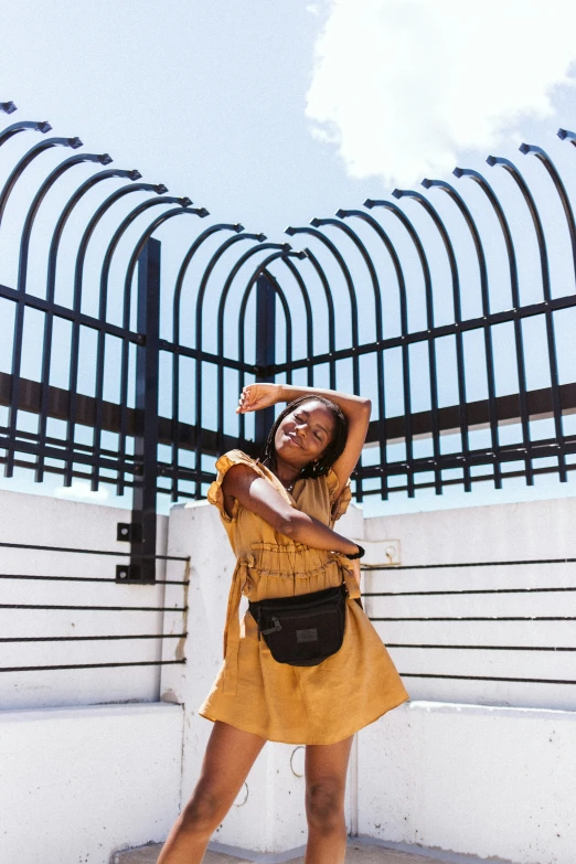 a woman standing in front of a metal fence