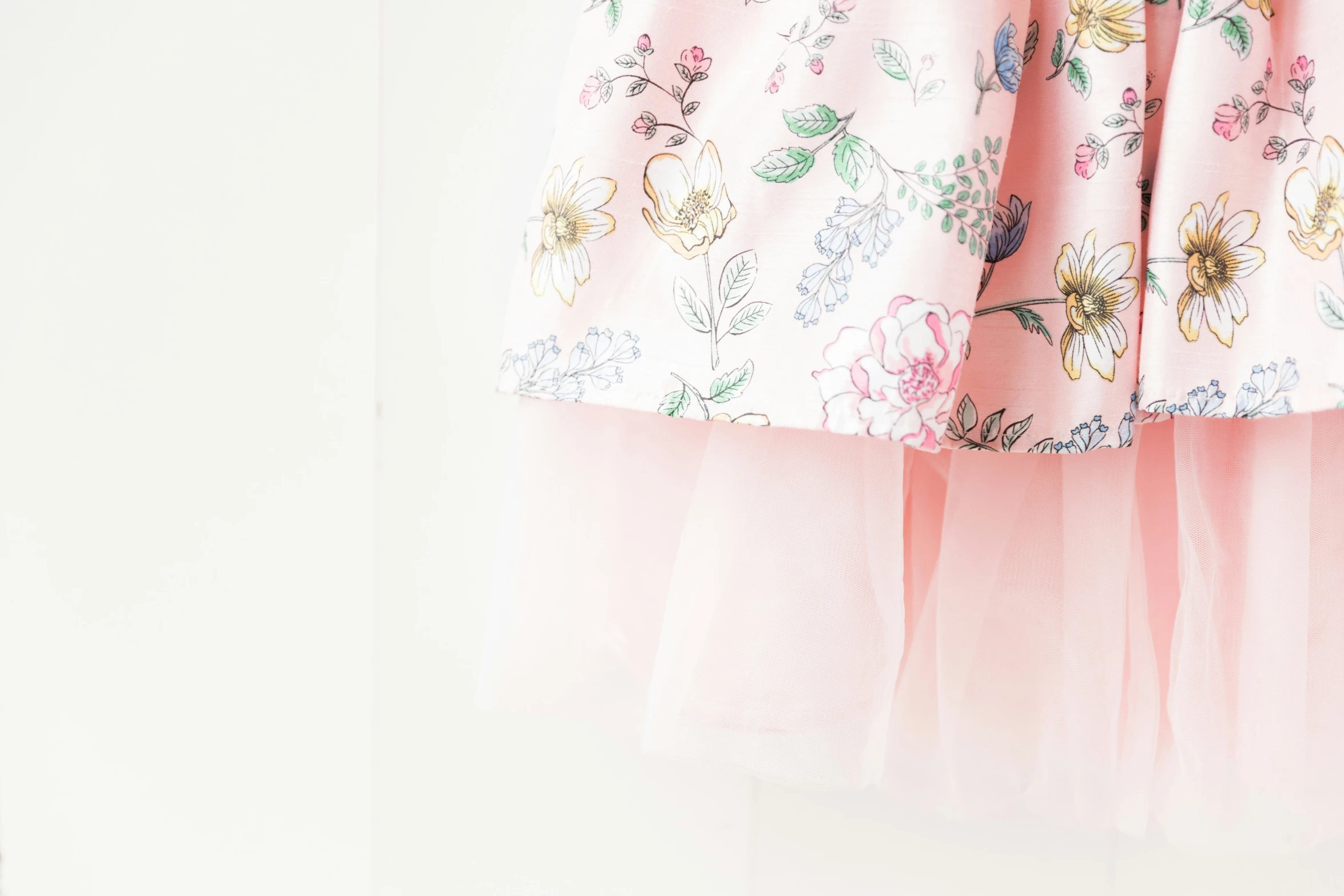 a close up of an unmade pink dress hanging on a wall