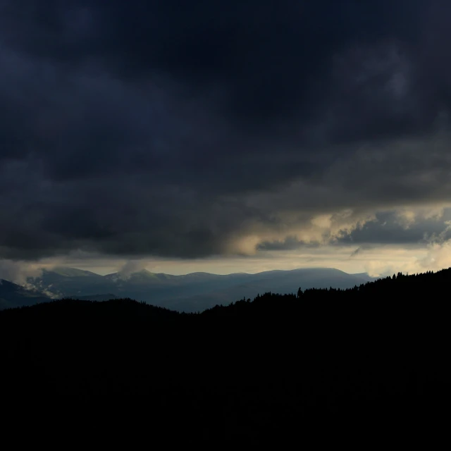 a mountain range with a dark colored sky