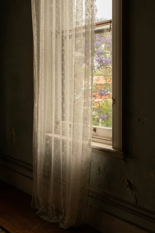 sunlight shining through the sheer curtains into a room