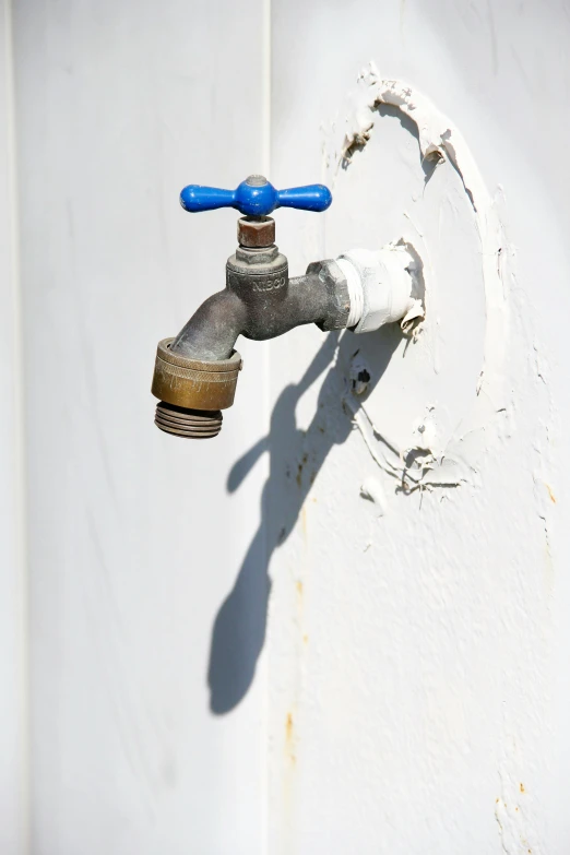 there is a red and blue water faucet next to a wall