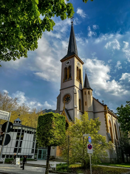 a church steeple is visible through a bunch of trees