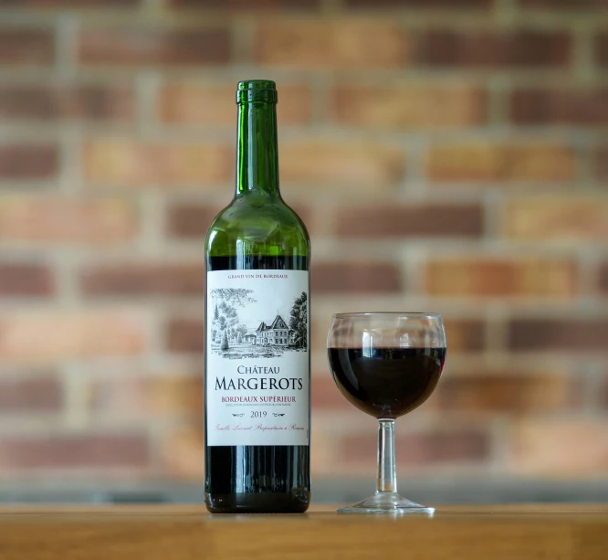 a glass and bottle of wine on a table