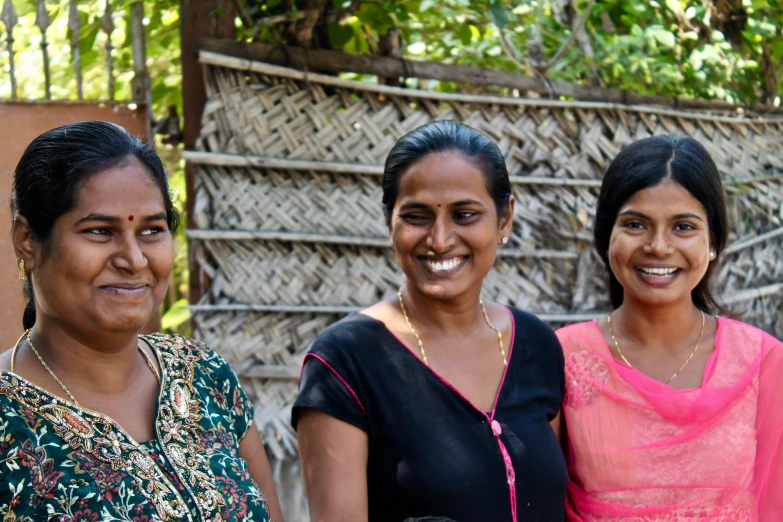 three women smiling and smiling in front of a house