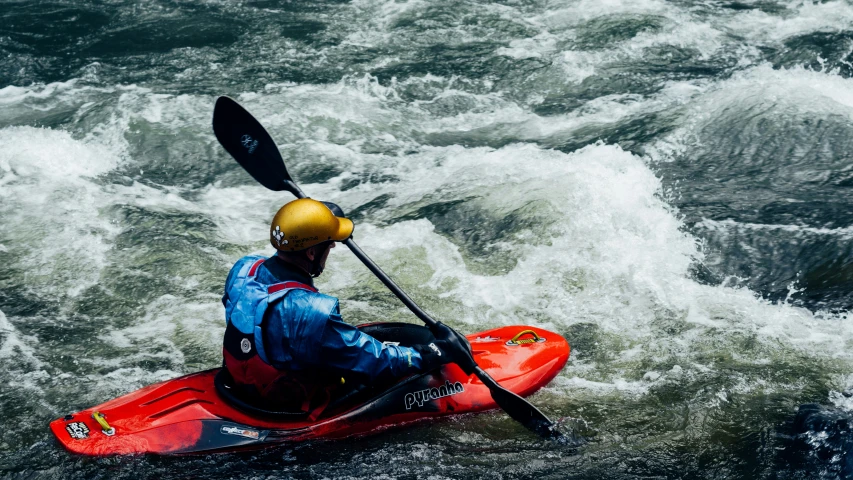 the person in the kayak has a yellow helmet on