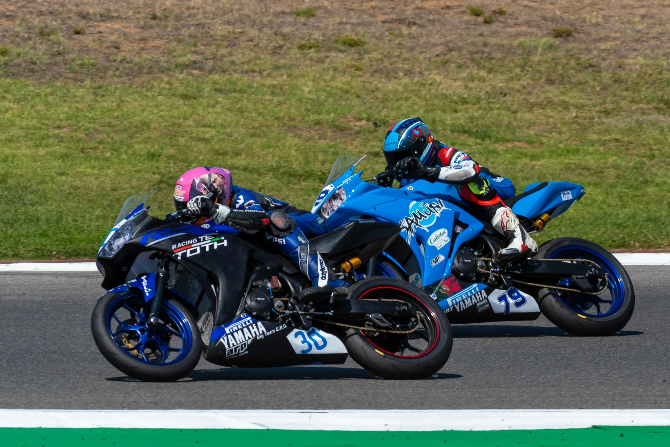 two motorcycle racing down a winding race track