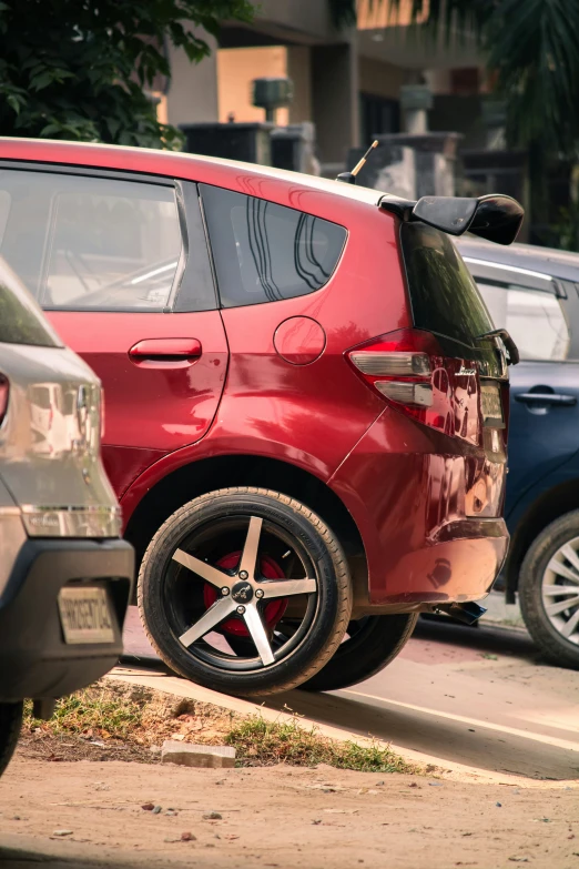 the red car is parked beside the black one