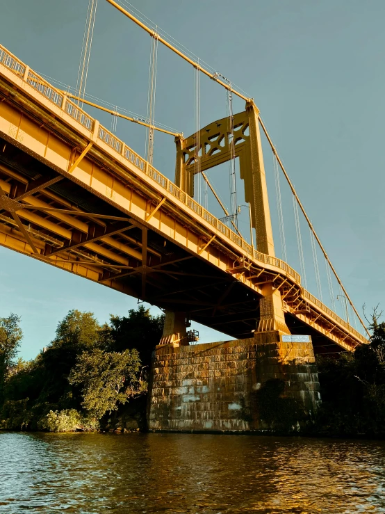 a large bridge over a river next to a forest