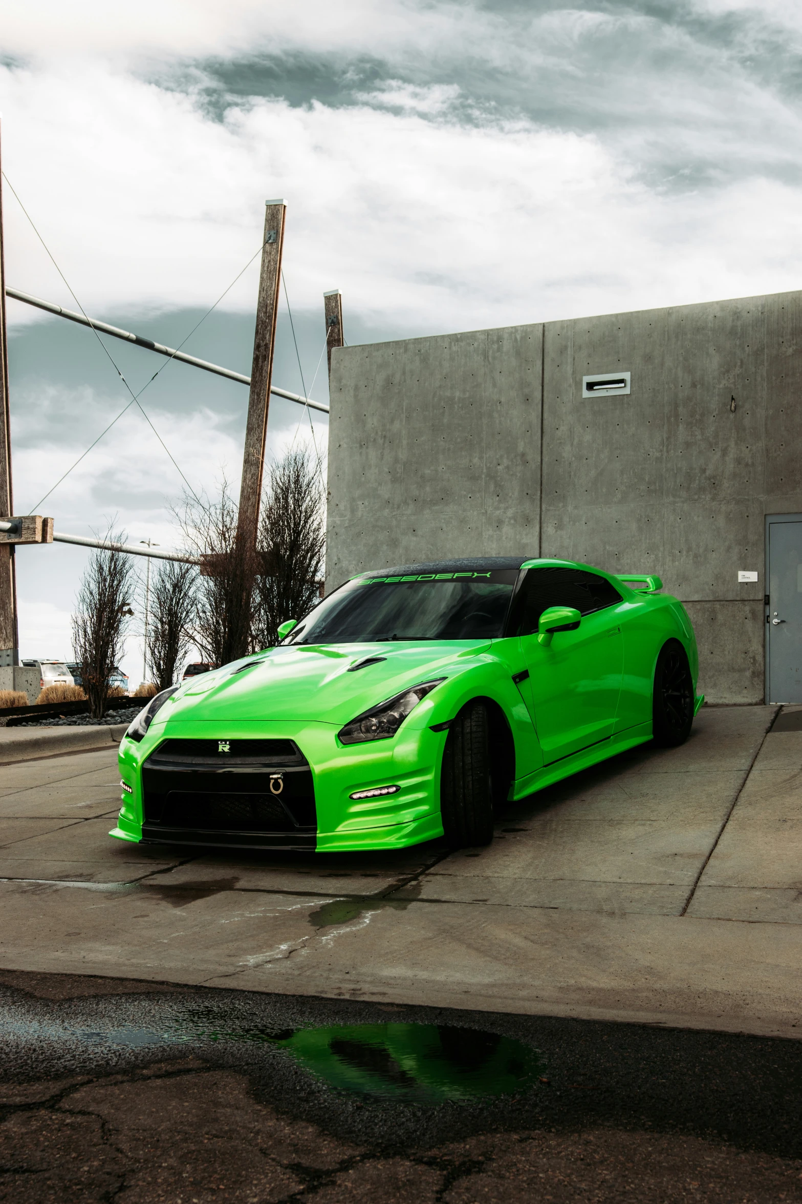 a bright green sports car parked on concrete outside