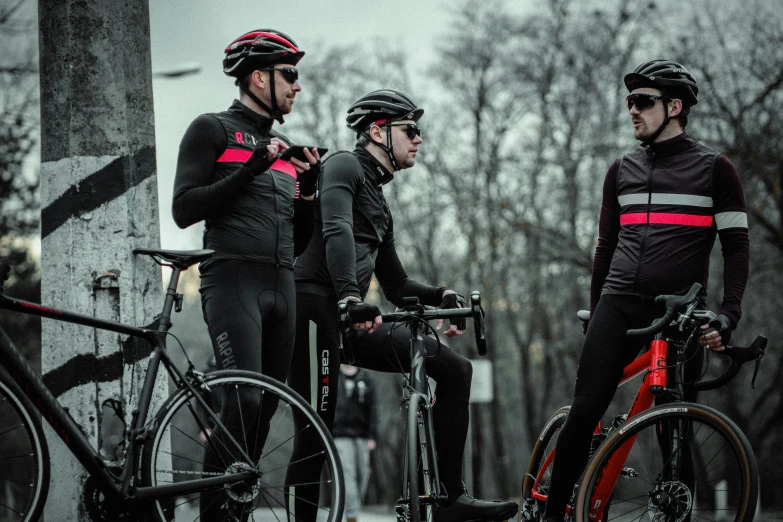 three people that are standing up next to their bikes