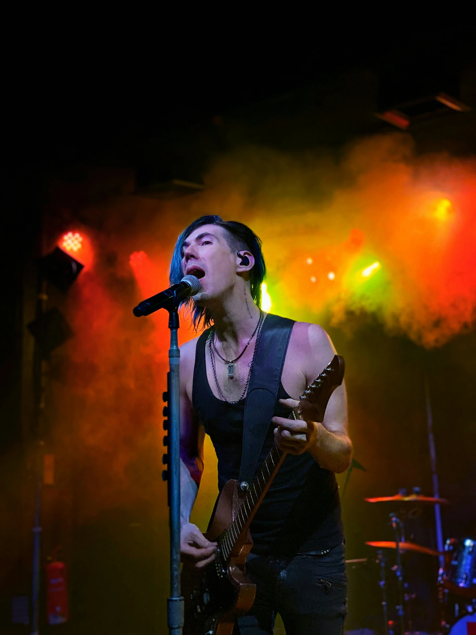 the young male singer is singing in a dimly lit concert