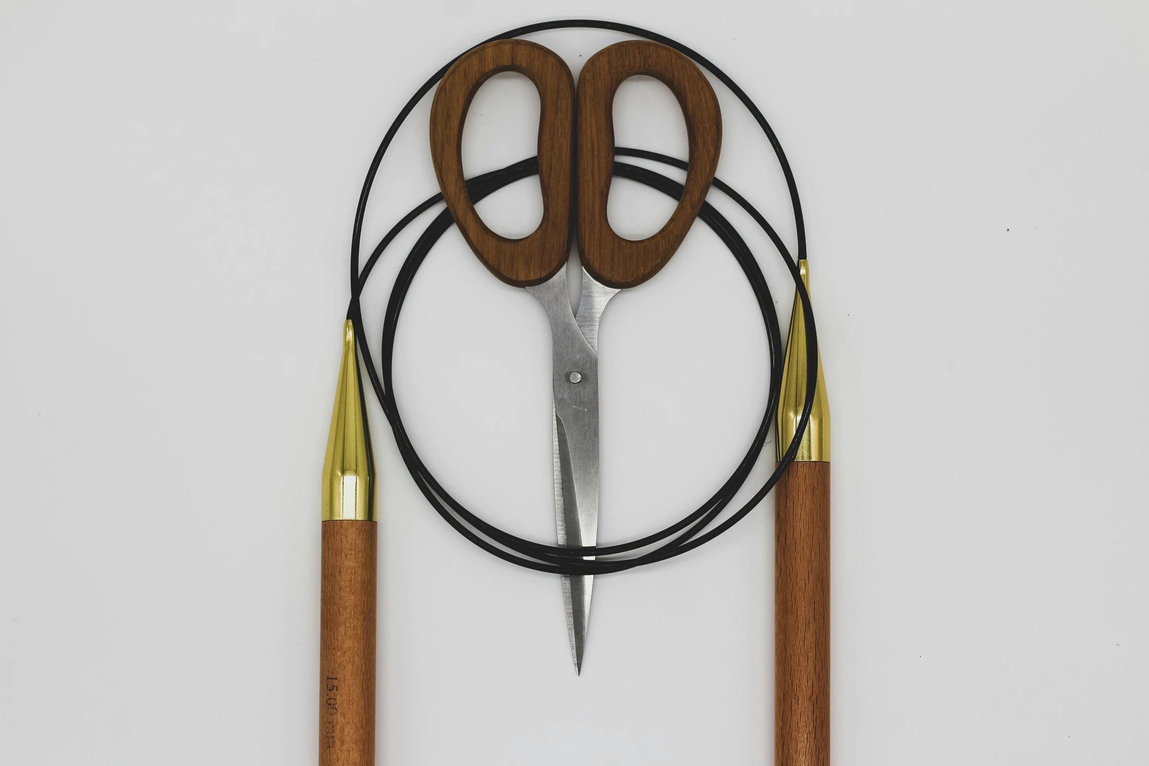 three scissors and wire on a white surface