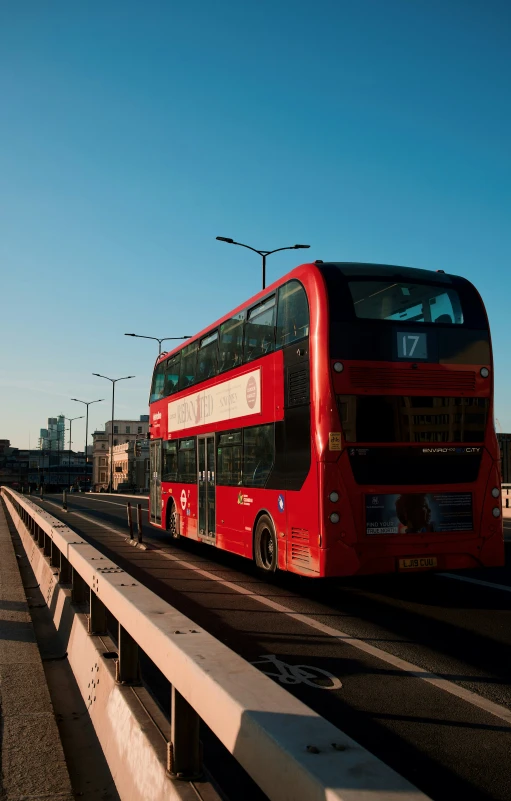 the double decker bus is traveling on the road