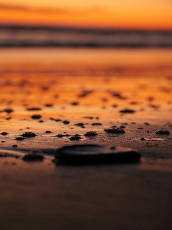 a close up of some sand and water with a sky background