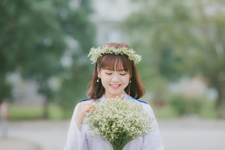 a girl wearing a flower crown holds a bush