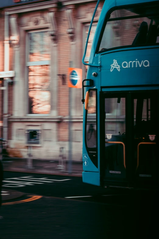 a large long blue bus parked next to a building