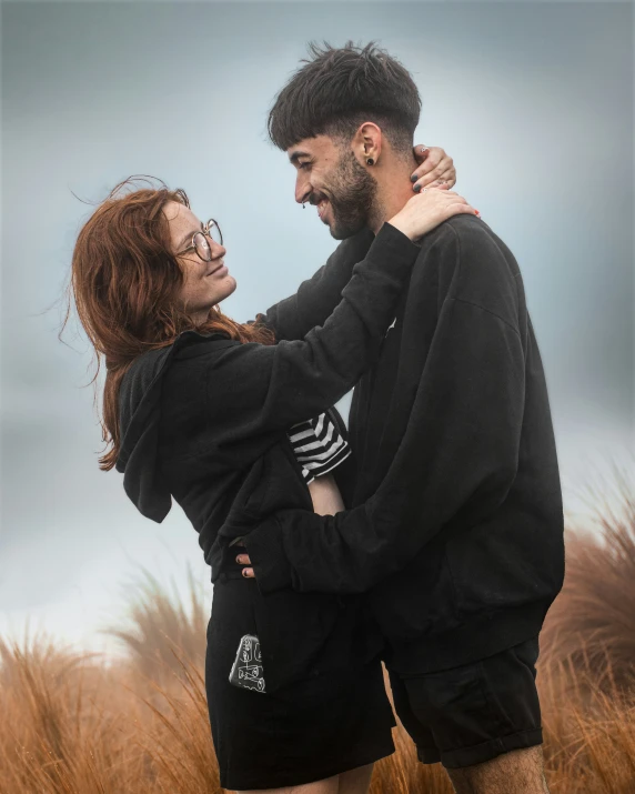 man and woman emcing with a field of tall grass in the background