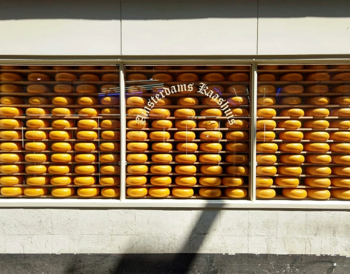 a display of cheese covered doughnuts in front of a store window