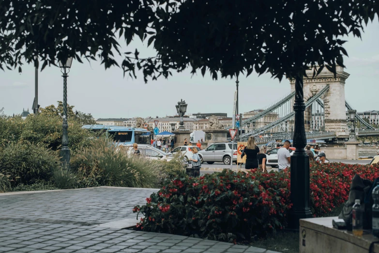 view from top of a small park in front of a bridge with people walking