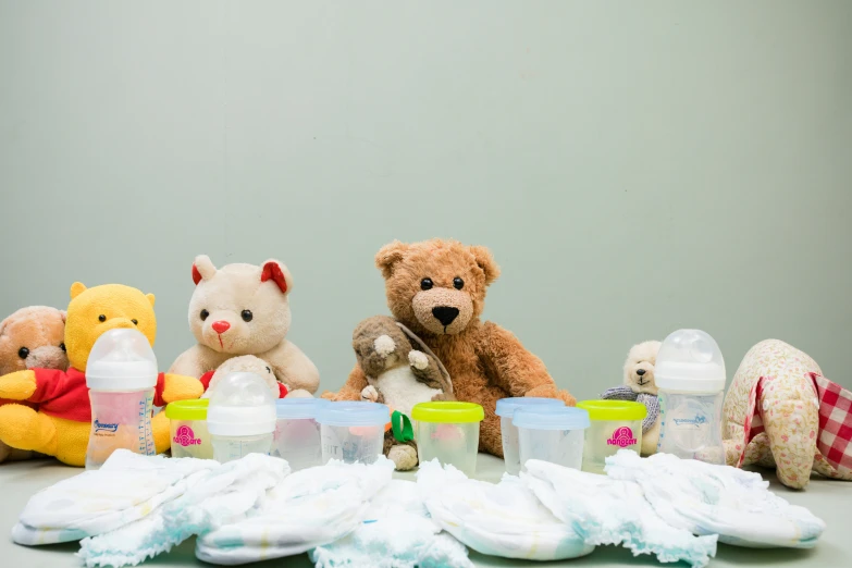 the baby bottles are sitting behind several stuffed animals