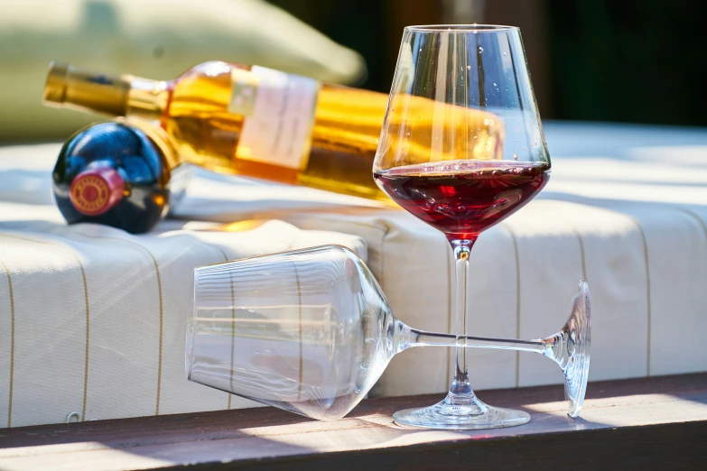 a wine glass, bottle, and a cork on a table