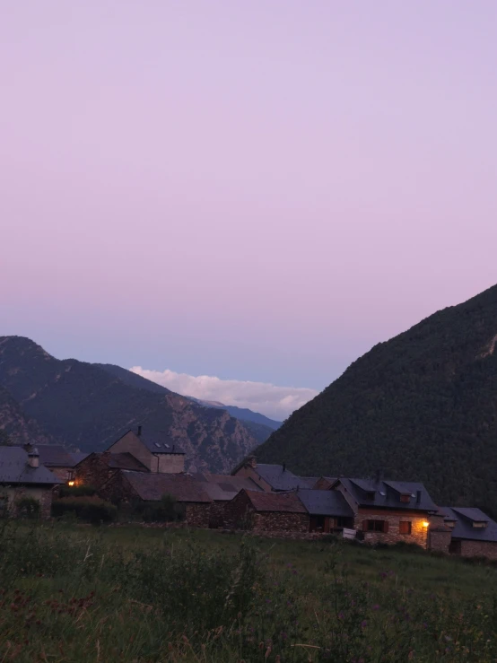 a view of a valley in the mountains at dusk