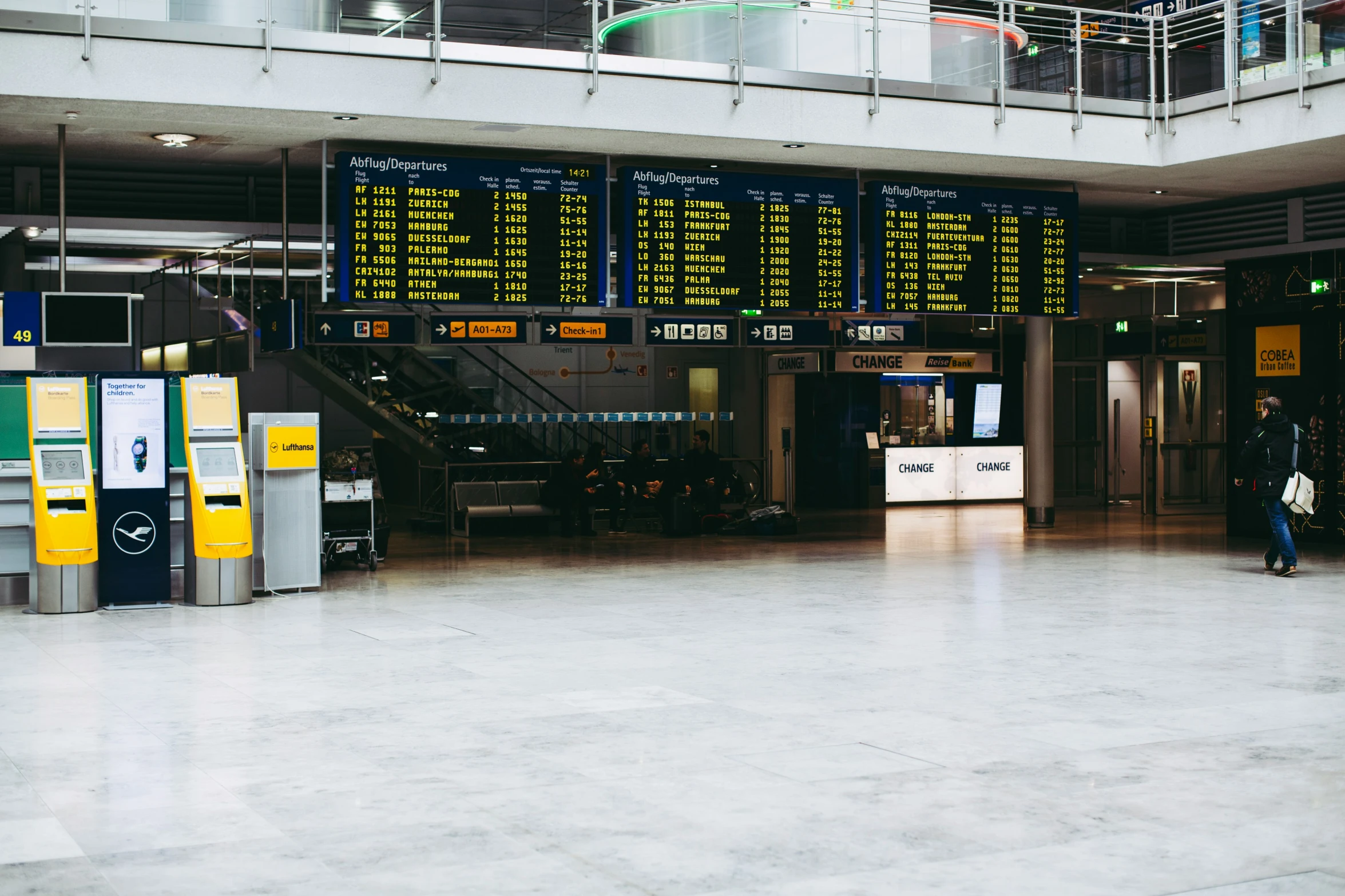 an airport baggage claim with two people looking at the display