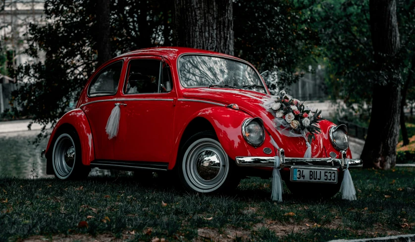 the classic red car has a silver beetle decoration on it