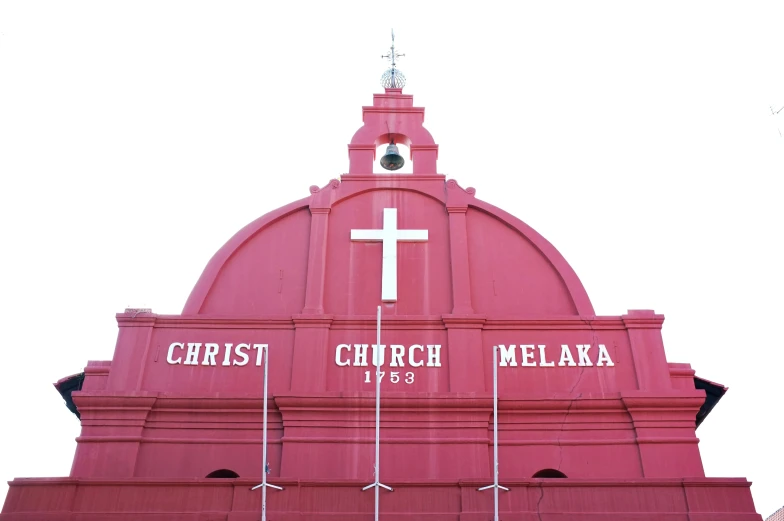 a large pink church has some flags on it