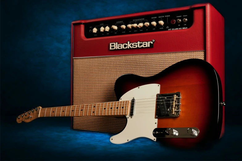 a guitar sitting next to a red amplifier