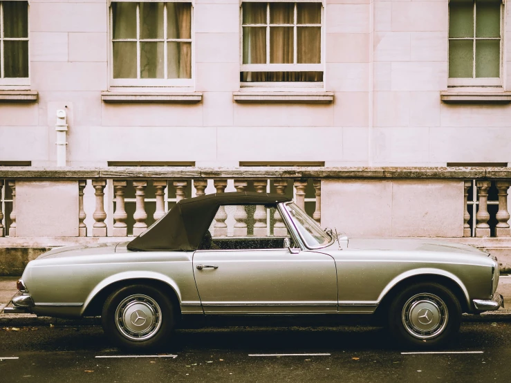 an old car is parked in front of a building