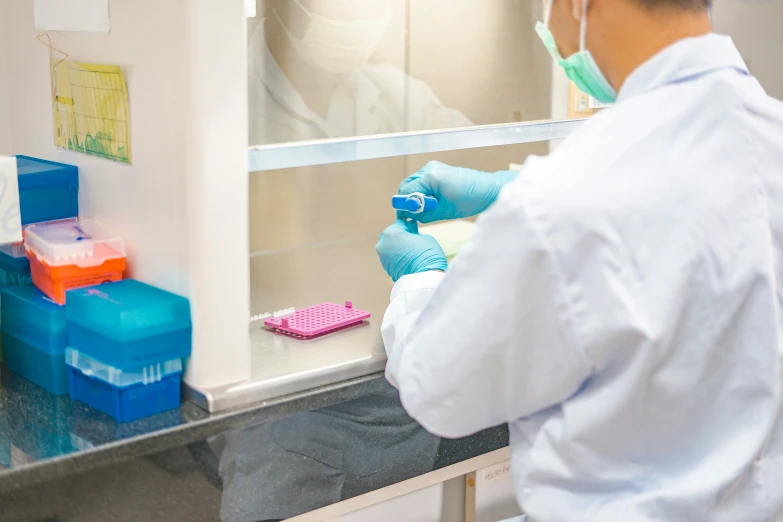 the scientist is doing experiments in a room with two other people