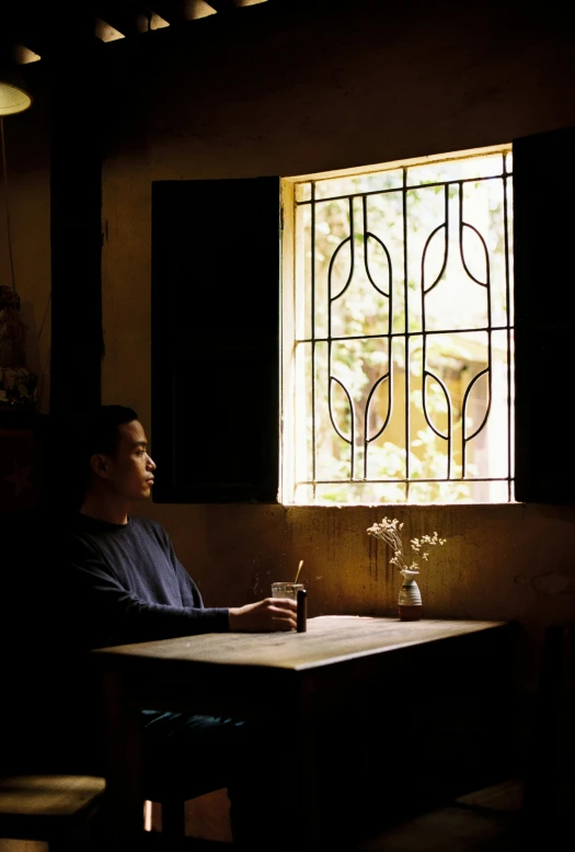 a man sitting at a table looking out of a window