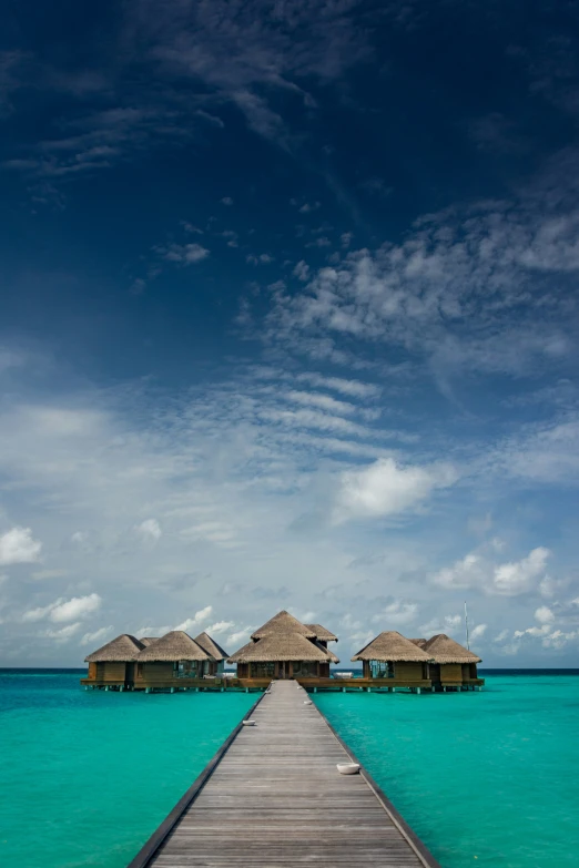 a wooden bridge leads into over water cottages